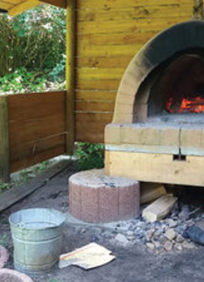 Bild von Baui heizt den Lehmofen ein | Brotbacken