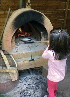 Bild von Baui heizt den Lehmofen ein | Gemeinsames Brotbacken