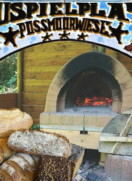 Baui heizt den Lehmofen ein